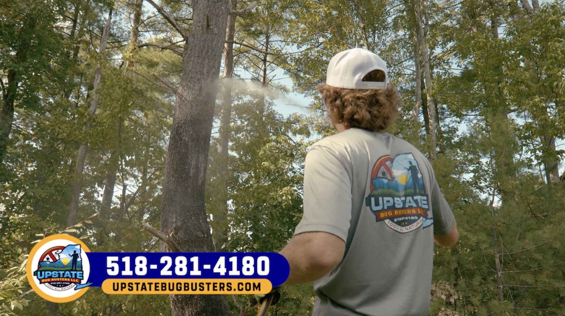 UBB technician spraying along a wooded yard