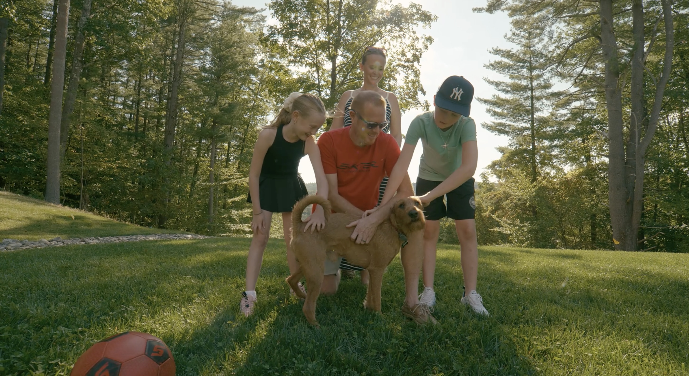 Family enjoying their yard together with their dog